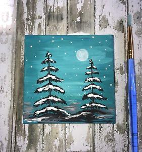 Small painting of fir trees on rustic wooden background 