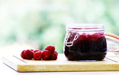 jam bottle with raspberries on cutting board