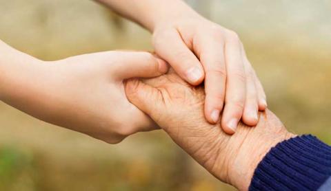 Child and senior holding hands