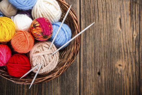 basket with balls of yarn and needles