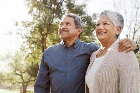 A man and woman standing close together outside