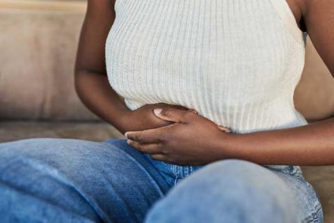 photo of woman with her arms wrapped around her abdomen.