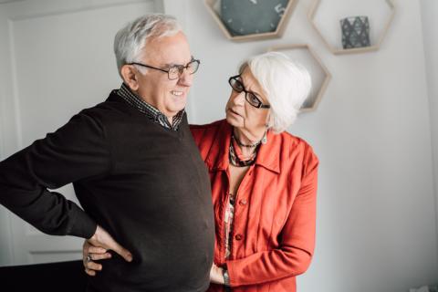 Man grimacing in pain while a woman looks concerned about him.