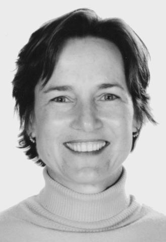 a black and white headshot of a woman smiling with short hair