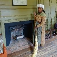 Gwendolyn Quezaire-Presutti performing a character in front of a fireplace