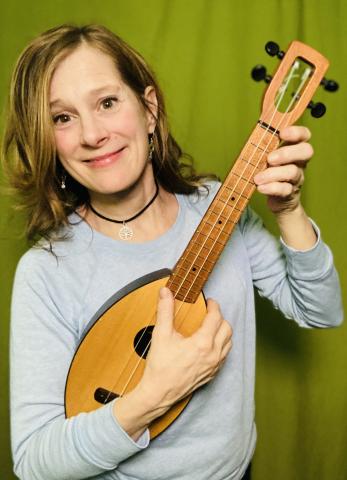 photo of Julie Stepanek smiling and holding a ukulele