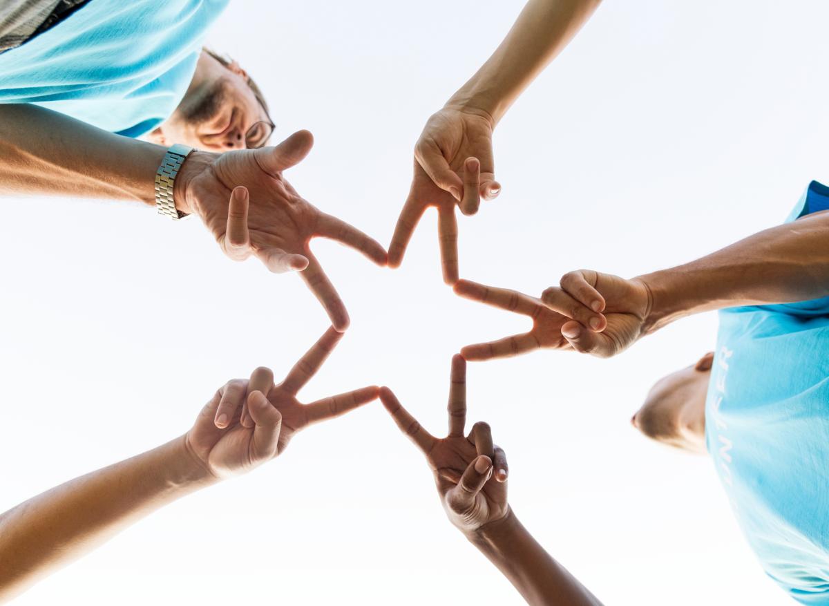 Teenagers forming a star with their fingers