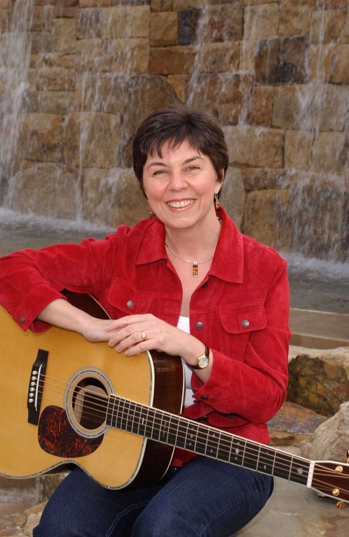 Performer sitting outdoors with guitar 