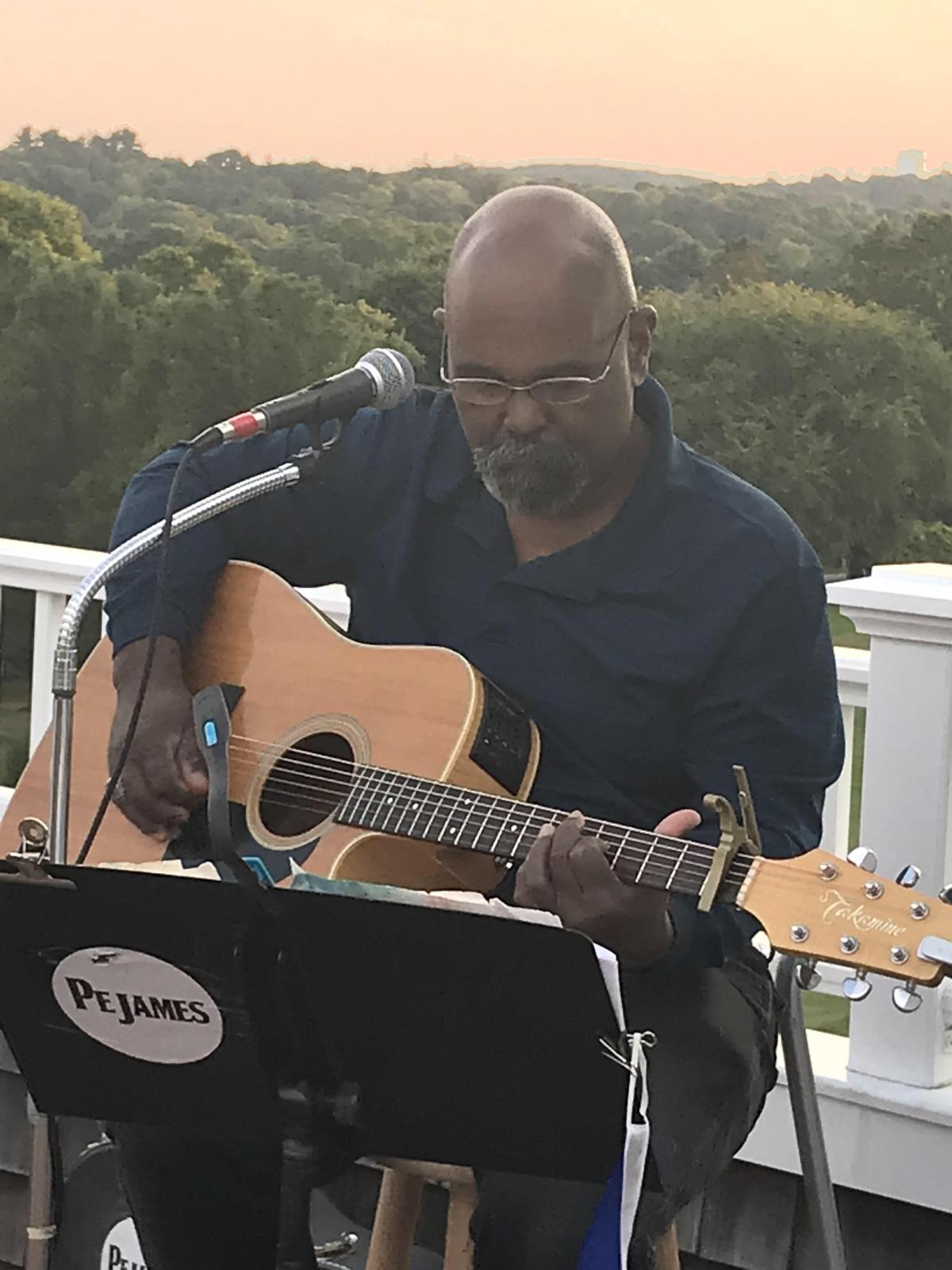 Presenter with guitar trees and hills background