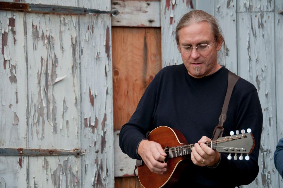 musician with mandolin in front of building