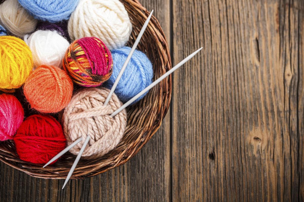 basket with balls of yarn and needles