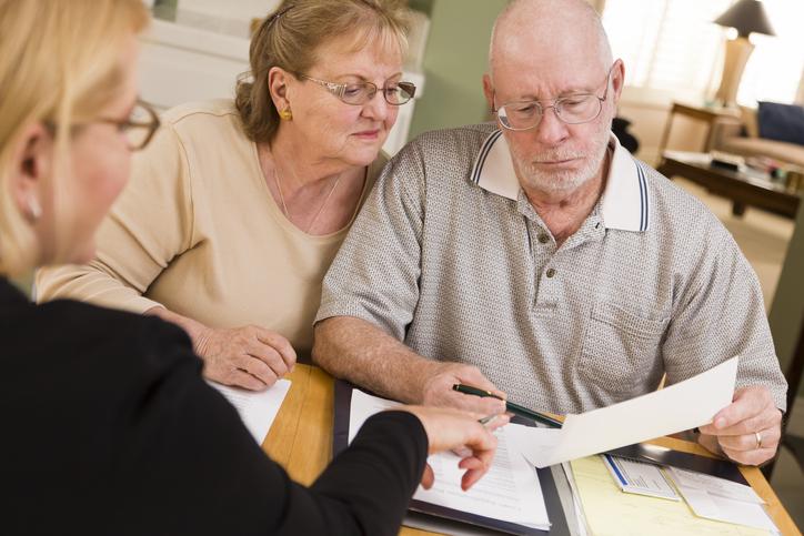 Three people looking over paperwork.