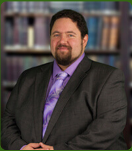 Steven Rubin in a Black Suit with a Purple Undershirt and Purple Patterned Tie