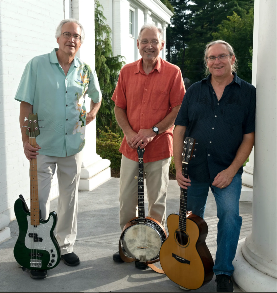 Three men with different musical instruments standing outside on the barney library back steps 