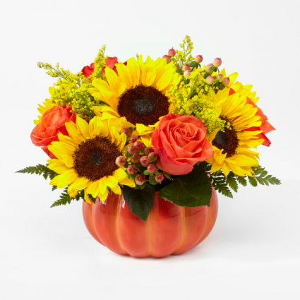 pumpkin with fall colored flowers inside