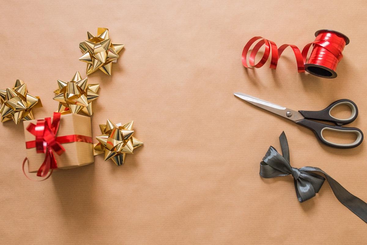 brown paper background with ribbons and scissors and a wrapped box